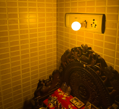 A yellow lightbulb lit above a wooden altar