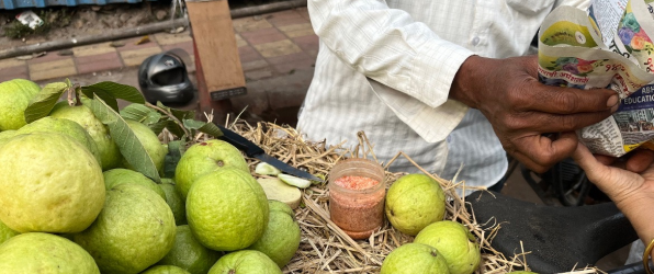 A vendor selling guavas from a basket